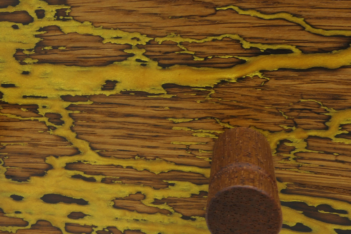 Detail der Lichtenberg-Struktur mit gelb-goldener Epoxidharzfüllung und Mahagonihaken